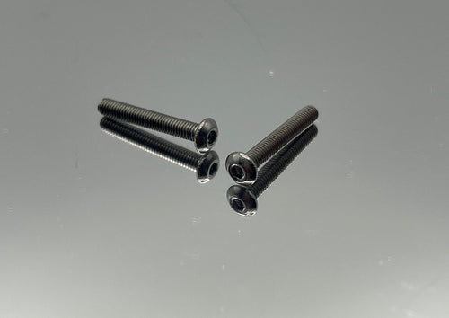 Two titanium screws on a reflective surface