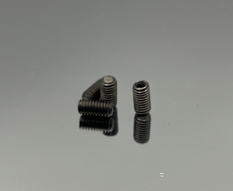 Two metal screws on a reflective gray surface