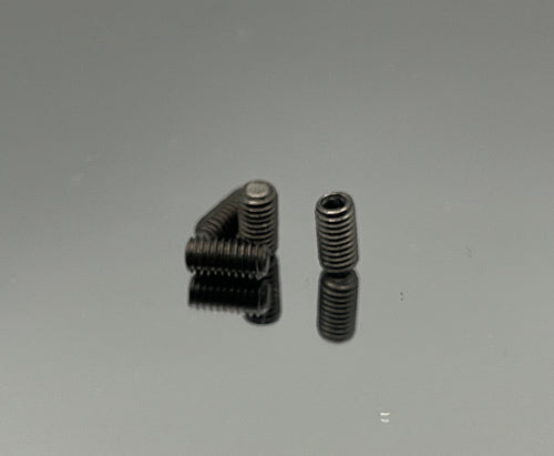 Two metal screws on a reflective gray surface
