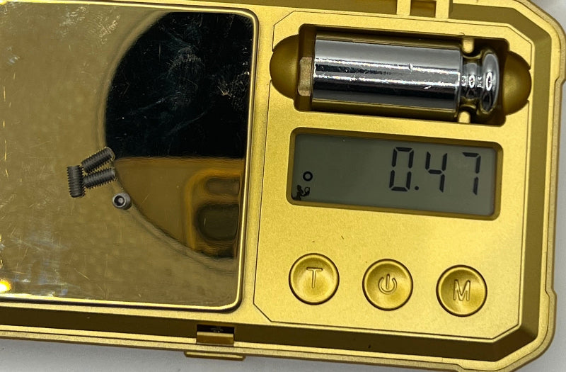 Gold metal detector with digital display showing 0.47, battery compartment, and control buttons.